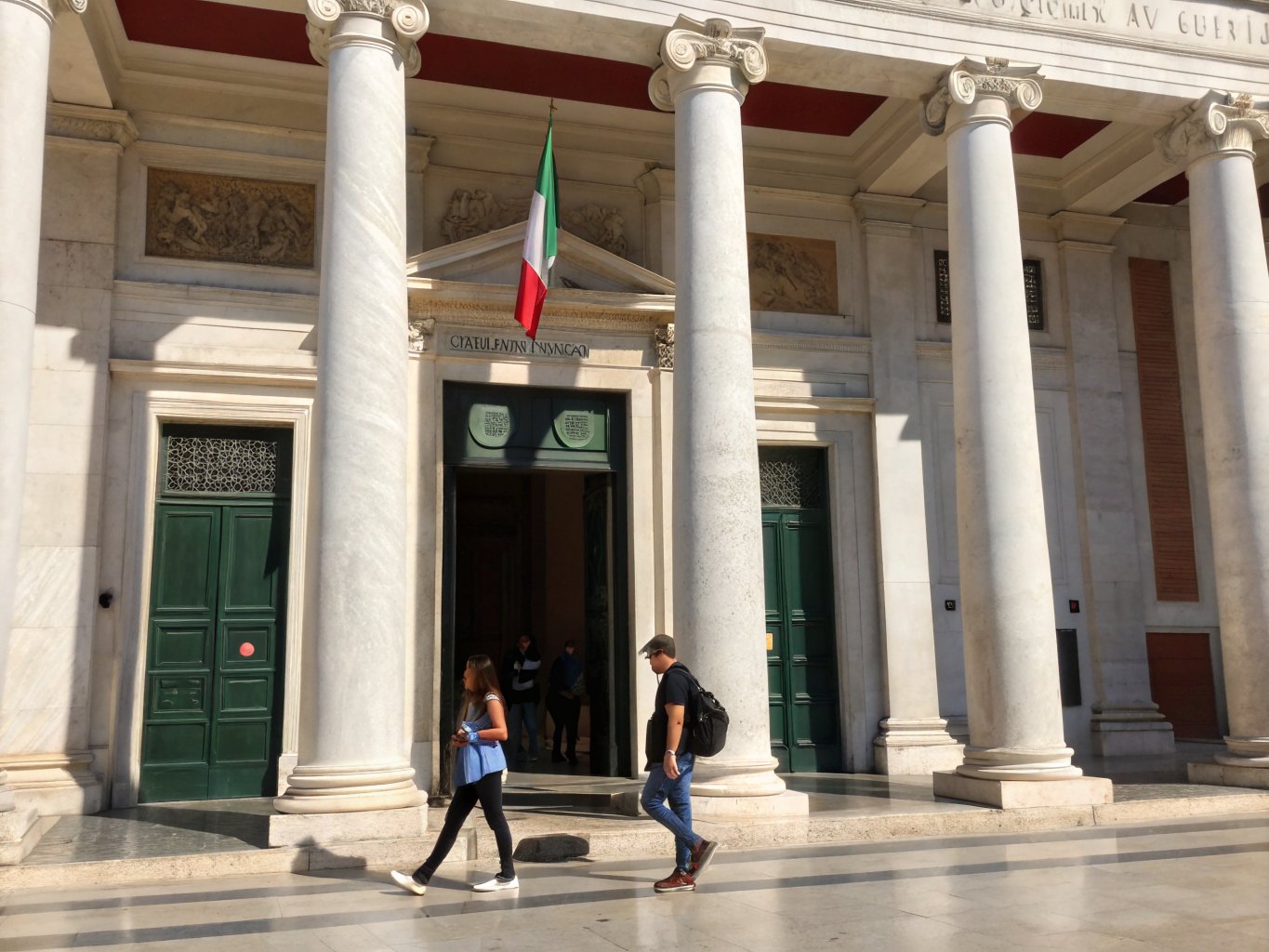 International students walking in front of a historic Italian university building